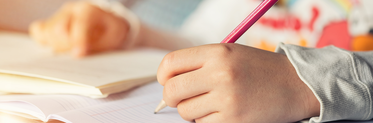 Student writing content in notebook